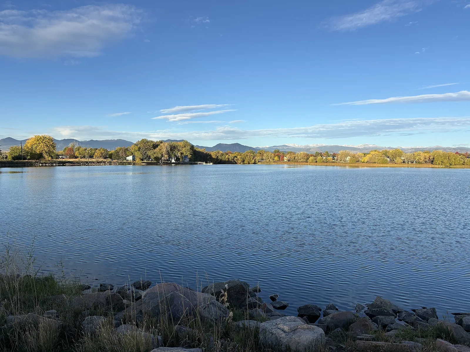 Waneka Lake with autumn trees and the Front Range in Lafayette, Colorado