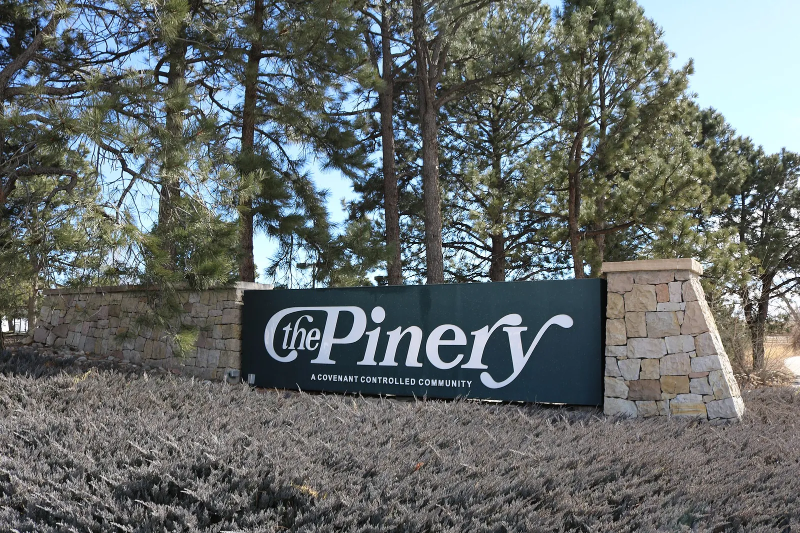 The Pinery community entrance sign among pine trees in Douglas County, Colorado